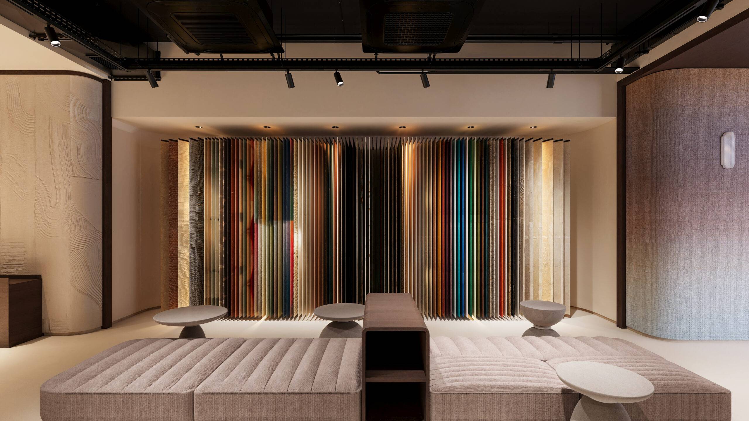 Visualisation 3D réalisée par Pierzo de l'espace central du showroom Élitis à New York, illustrant un concept de retail design 3D spacieux avec présentoirs textiles.