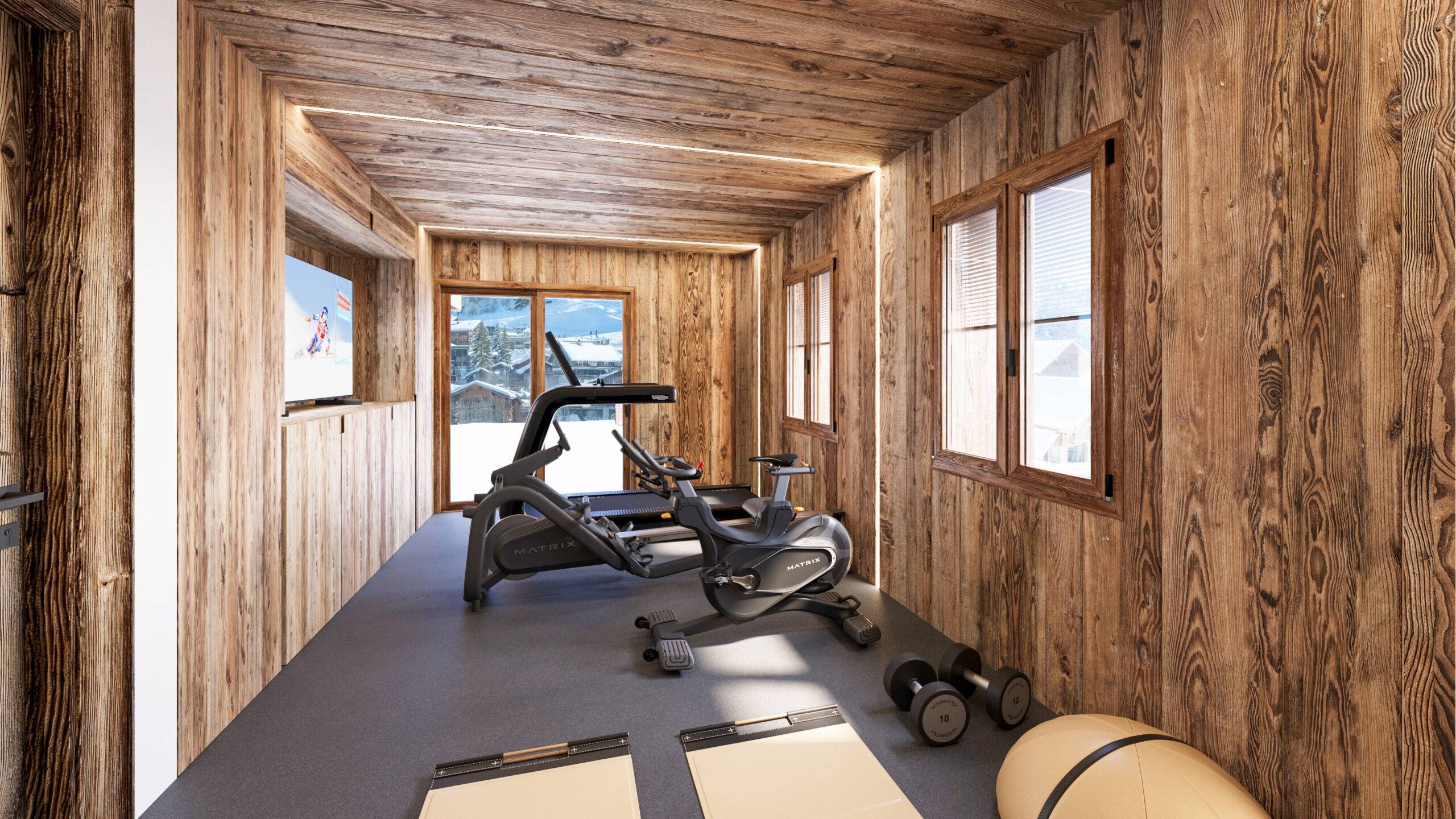 Perspective intérieur chalet 3D de Pierzo d'une salle de sport toute équipée avec des murs en bois et une baie vitrée donnant sur la vue à La Clusaz.